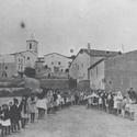 Imatge de la part posterior de la masia (1919) durant una cantada dels nens i nenes de les escoles al primer camp de futbol situtat a Cal Llom.